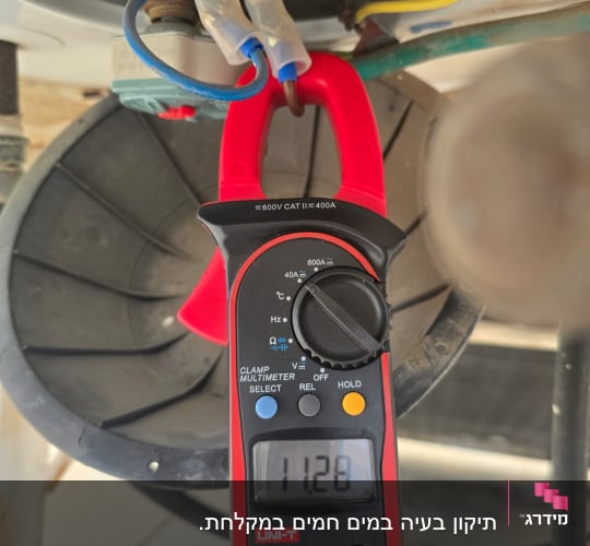 מד מתח מחובר לחוטים חשמליים בצנרת